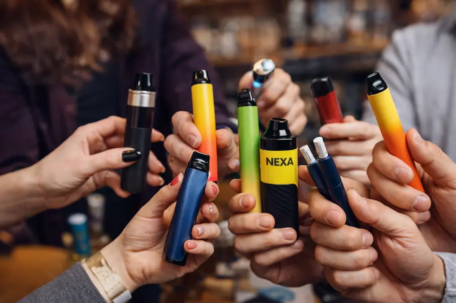 los mejores vapes en 2026 Vapes desechables de gran tamaño y colores variados utilizados en un entorno social